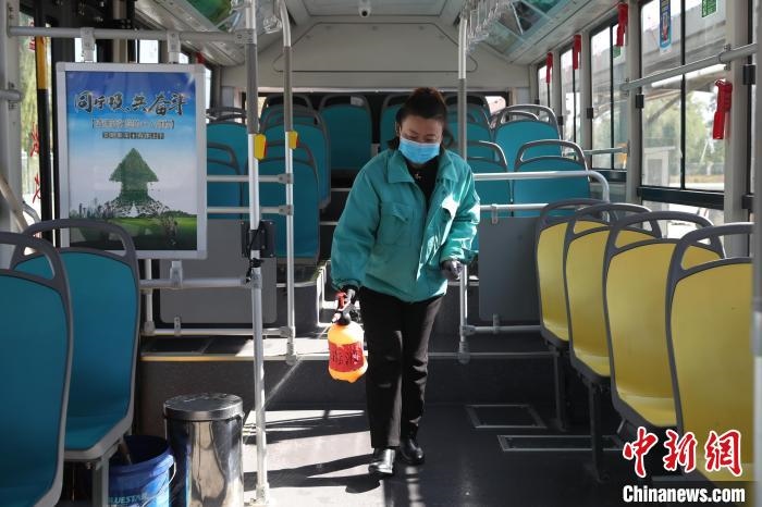 工作人員正在對(duì)公交車進(jìn)行消殺?！∮诰?攝