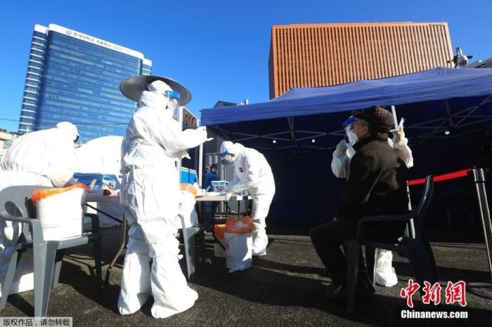 資料圖：韓國首爾，醫(yī)務(wù)人員對市民進(jìn)行新冠病毒檢測。