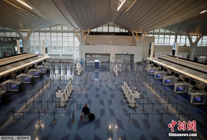 資料圖：日本東京，東京國際機場，一名乘客在國際航班航站樓的登機區(qū)。
