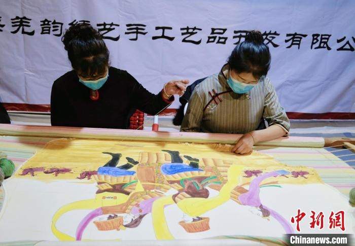 圖為皮繡藝人在市集上“秀”指尖技藝。　馬銘言 攝