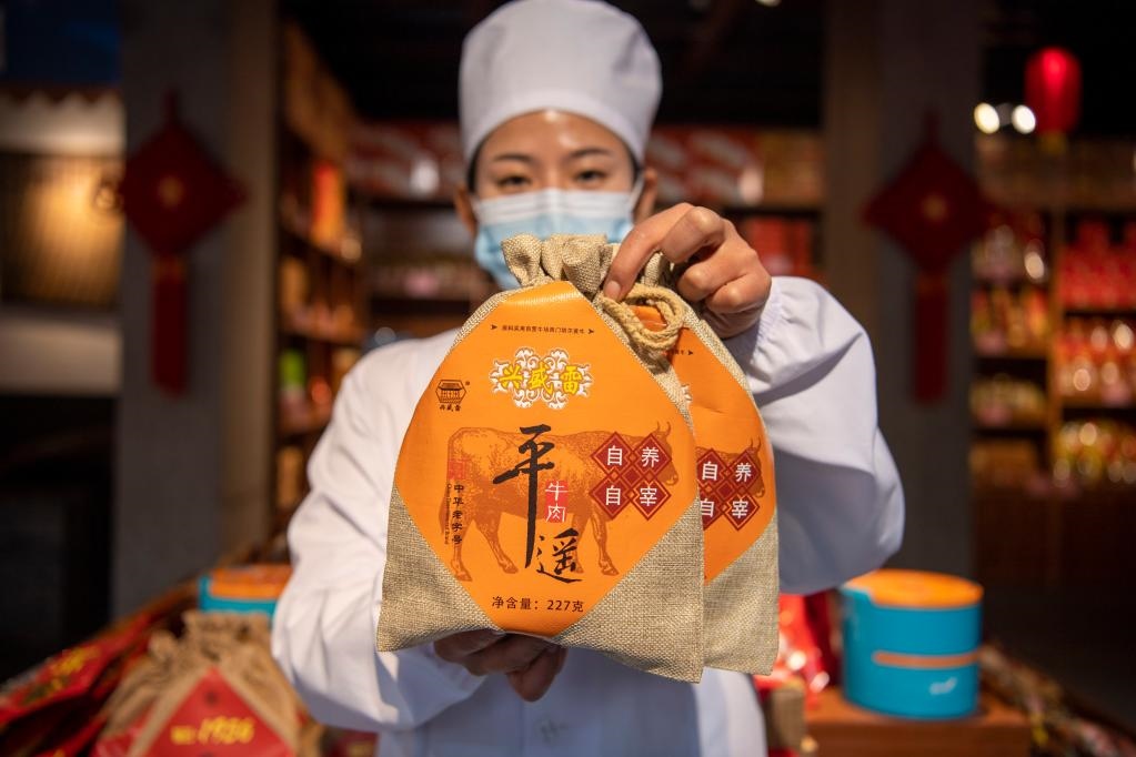 1月27日，在平遙古城南大街的一家平遙牛肉店內(nèi)，工作人員展示一款牛肉產(chǎn)品。新華社記者 楊晨光 攝