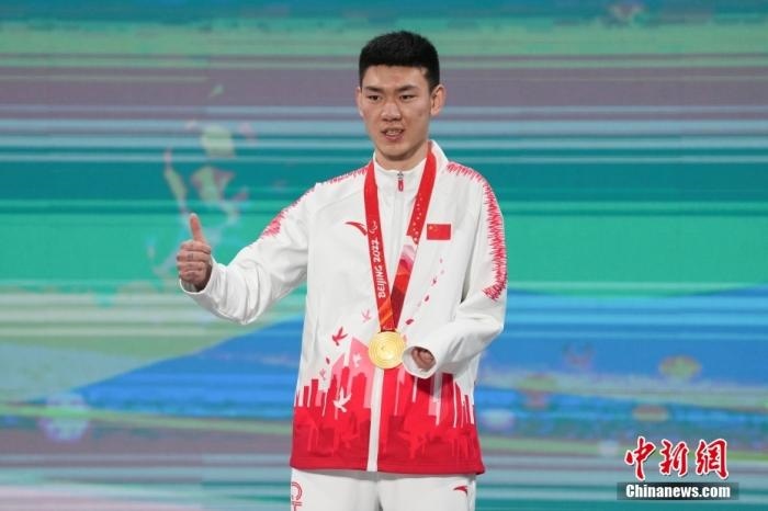 3月6日，梁景怡在延慶頒獎廣場領(lǐng)獎臺上豎起大拇指。當(dāng)日，在國家高山滑雪中心舉行的北京2022年冬殘奧會殘奧高山滑雪男子超級大回轉(zhuǎn)—站姿決賽中，中國選手梁景怡奪得冠軍。 <a target='_blank' href='/'>中新社</a>記者 楊華峰 攝