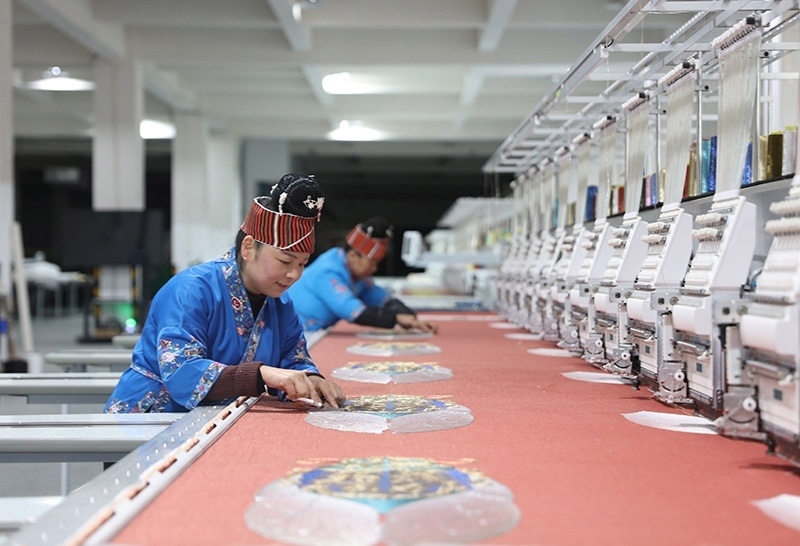 2023年2月13日，貴州省黔東南苗族侗族自治州施秉縣工業(yè)園區(qū)，工人在機(jī)繡車間作業(yè)。