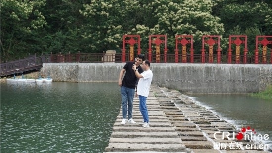 “一帶一路”國(guó)際青年走進(jìn)信陽羅山 看“紅”“綠”資源助力鄉(xiāng)村未來_fororder_國(guó)際青年在九龍河上拍照記錄 攝影 賈親親.JPG