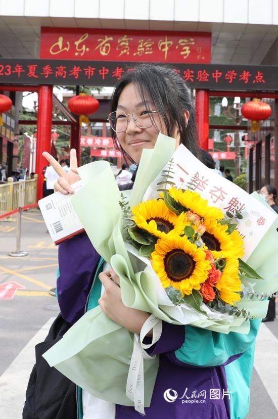 6月7日高考首日，山東67萬考生走進(jìn)考場，拼搏逐夢。在山東省實(shí)驗(yàn)中學(xué)考點(diǎn)，考生進(jìn)考場前手捧向日葵花拍照留念，寓意“一舉奪魁”。人民網(wǎng)記者 劉祺攝