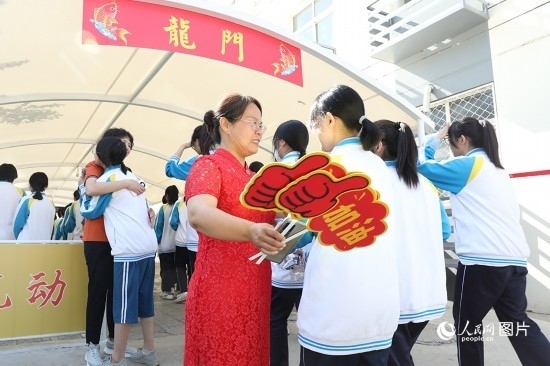 6月7日一早，雄安新區(qū)安新中學(xué)老師在給同學(xué)們加油鼓勁兒。人民網(wǎng) 李兆民攝