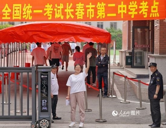 6月7日，在長春市第二中學(xué)考點(diǎn)，一名考生信心滿滿進(jìn)入考場，并與家長揮手致意。人民網(wǎng)記者 李洋攝