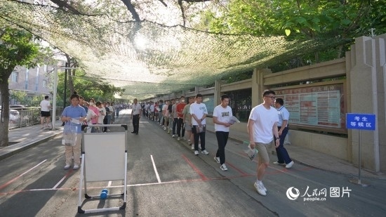 6月7日，烏魯木齊市第七十中學(xué)門口，考生們有序進(jìn)入考場。人民網(wǎng) 李欣洋攝