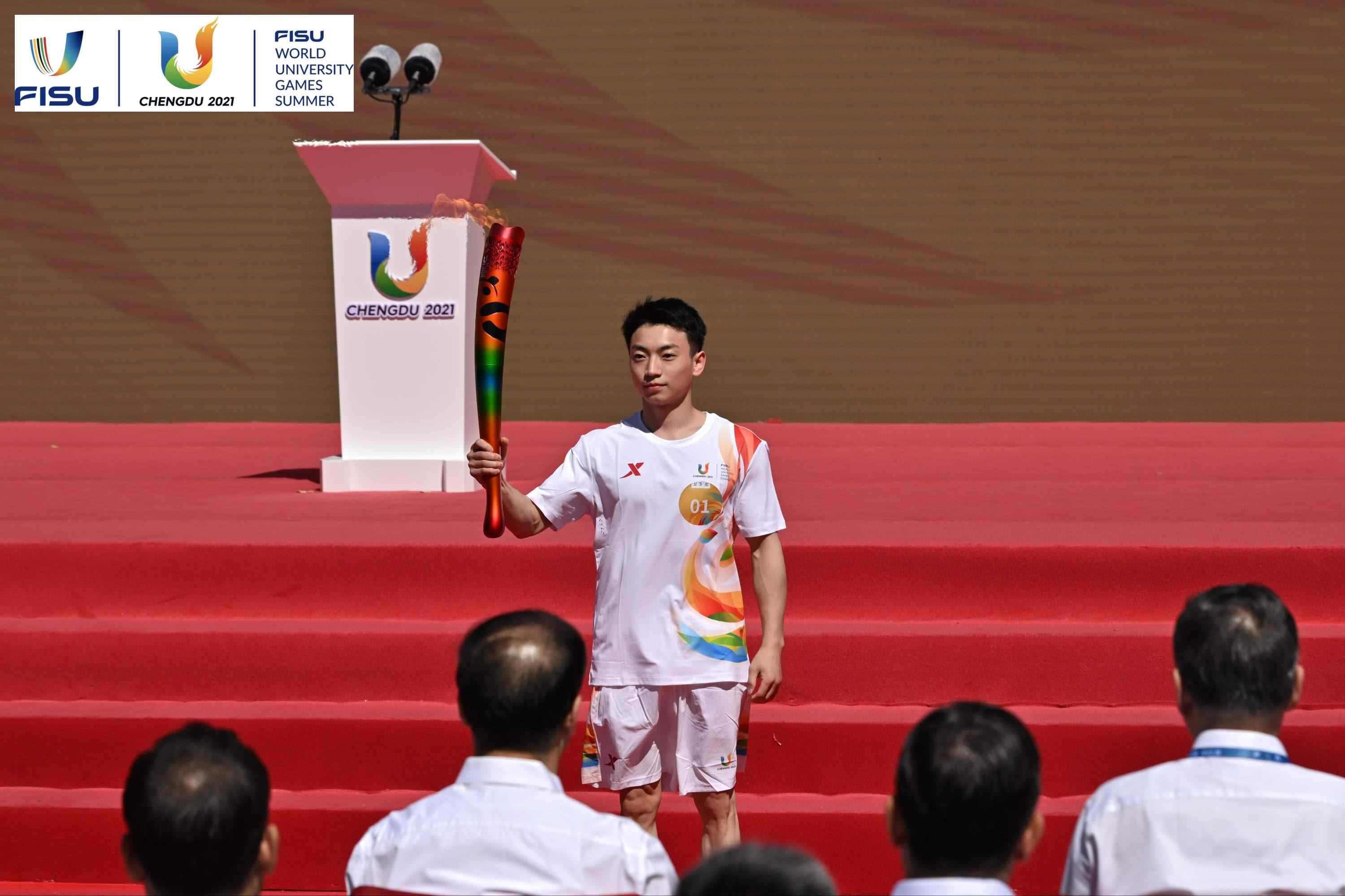 成都大運會火炬手、奧運冠軍鄒敬園高舉火炬。 圖片來源：成都大運會執(zhí)委會供圖