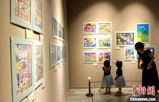 圖為家長帶著孩子參觀展覽。呂明 攝