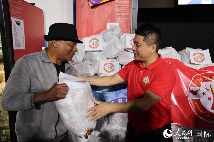 巴西中國浙江商會會長鄭俠茂向社區(qū)居民轉交捐贈物資。人民網(wǎng)記者 時元皓攝