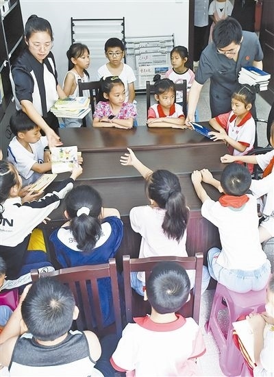  圖④：法院干警為留守兒童發(fā)放暑假讀物。