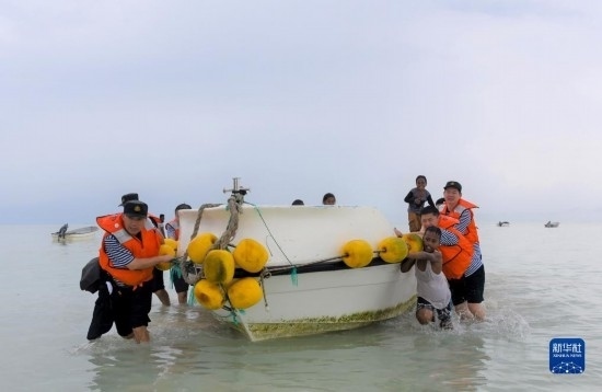 7月21日，中國海軍“和平方舟”號醫(yī)院船醫(yī)護人員涉水登島，前往基里巴斯一診療點。新華社記者 黎云 攝