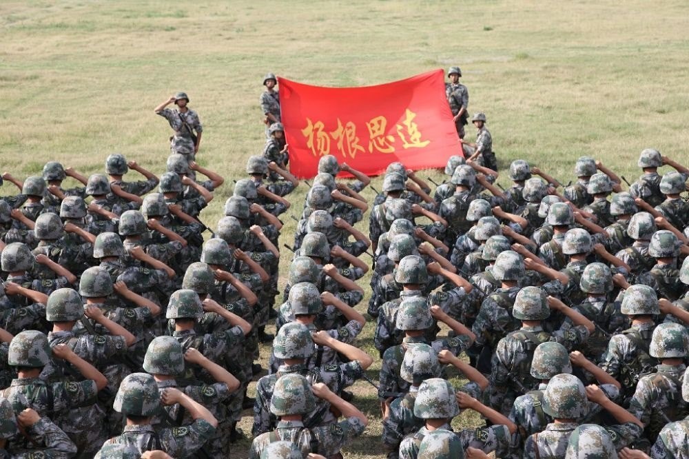 ↑“楊根思連”官兵執(zhí)行任務(wù)前向連旗宣誓（資料照片）。新華社發(fā)