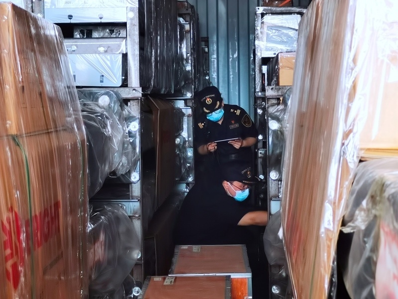 關(guān)員利用工業(yè)內(nèi)窺鏡在集裝箱內(nèi)進行查驗。人民網(wǎng)記者 栗翹楚攝