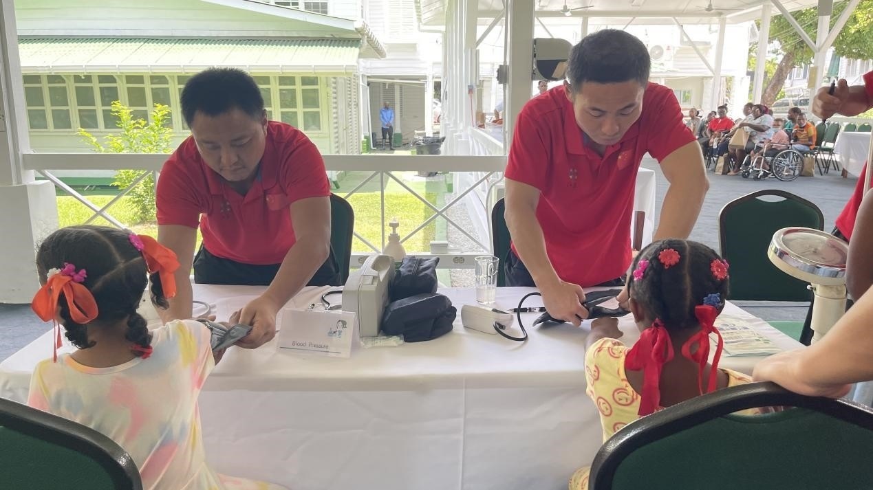 醫(yī)療隊(duì)員為福利院兒童進(jìn)行檢查。第18期援圭亞那醫(yī)療隊(duì)供圖