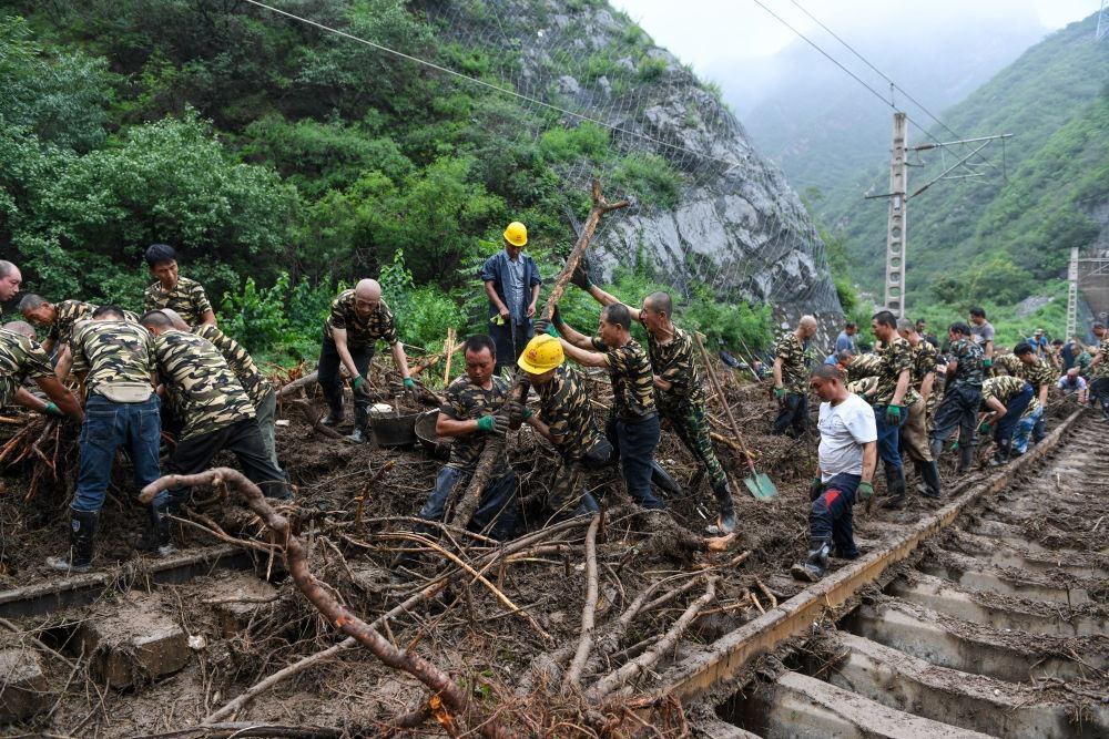 8月1日，在北京市門頭溝區(qū)水峪嘴村附近一段被阻斷的鐵路線上，中鐵六局工作人員在清理軌道上的雜物，全力恢復(fù)交通。新華社記者 鞠煥宗 攝