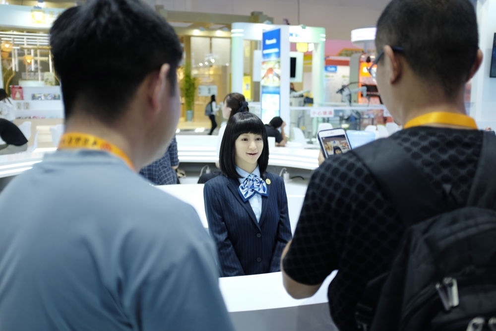 9月1日，媒體記者在國(guó)家會(huì)議中心與服務(wù)機(jī)器人互動(dòng)。新華社記者 劉夢(mèng)琪 攝