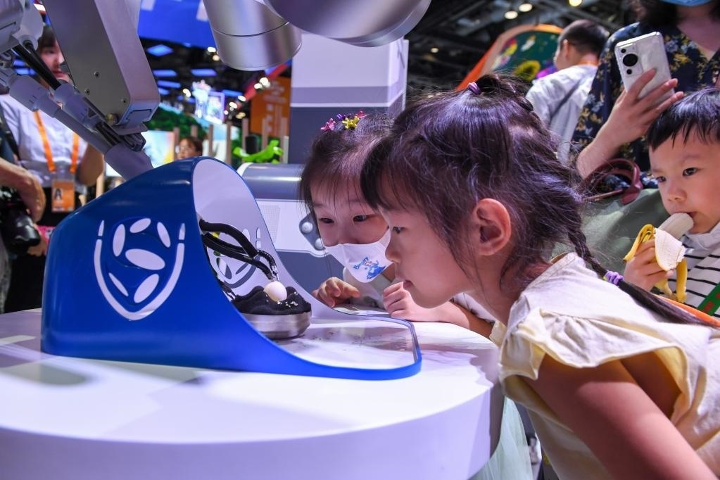 9月3日，幾名小朋友在國(guó)家會(huì)議中心觀看單孔腔鏡手術(shù)機(jī)器人展示。新華社記者 鞠煥宗 攝