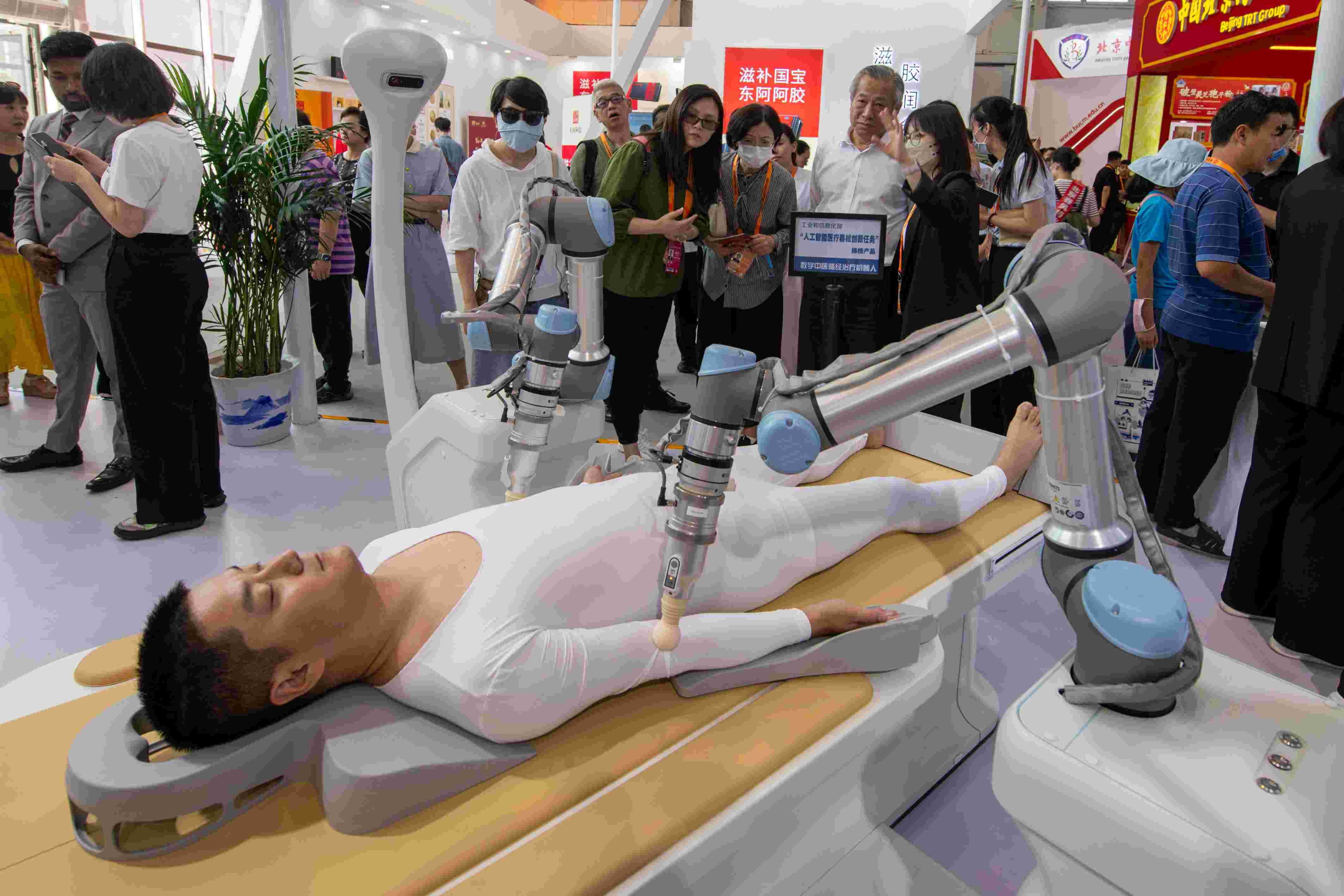 在位于首鋼園的健康衛(wèi)生服務展區(qū)，觀眾正在參觀數(shù)字中醫(yī)循經(jīng)治療機器人。人民網(wǎng)記者 翁奇羽攝