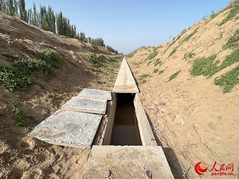打開蓋板，可見水在寬一米、深一米的渠道內暢通流過。人民網記者 常雪梅攝