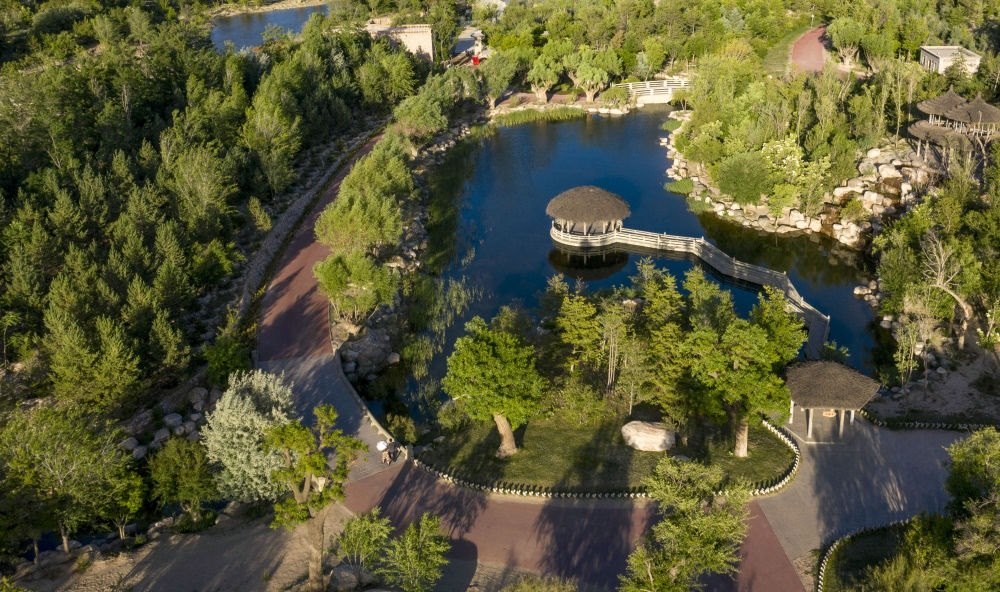 坐落在寧夏銀川市賀蘭山腳下的賀蘭山運(yùn)動(dòng)休閑公園（2021年5月27日攝，無(wú)人機(jī)照片）。這里曾是一片砂石采礦塌陷區(qū)，當(dāng)?shù)赝ㄟ^(guò)植被景觀再造、水系建設(shè)、現(xiàn)代管網(wǎng)鋪建等手段，重新利用廢石、廢坑及各類廢棄建筑材料，把這里變成一座免費(fèi)開(kāi)放的主題公園。新華社記者 馮開(kāi)華 攝