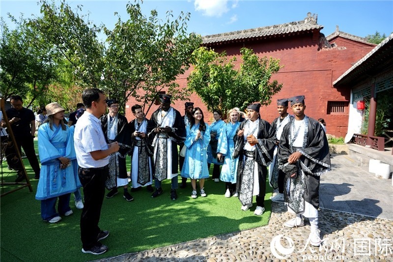 圖為選手們聽導(dǎo)游講解。人民網(wǎng) 盧鵬宇攝