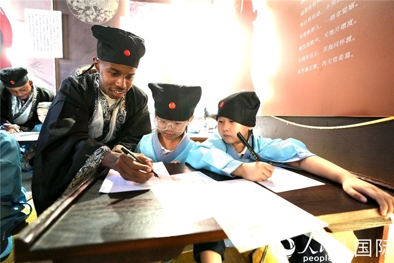 圖為選手與同學(xué)們一起寫書法。人民網(wǎng) 盧鵬宇攝