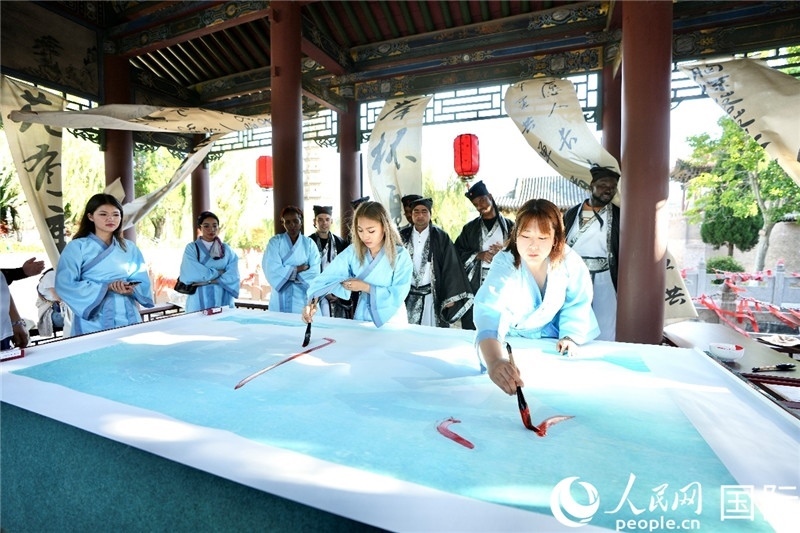 選手們提筆書寫“家園”二字。人民網(wǎng) 盧鵬宇攝