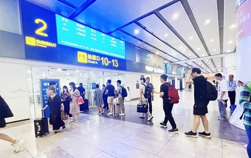 在快速進(jìn)站廳前排隊等待檢票的旅客。人民網(wǎng)記者 喬雪峰攝