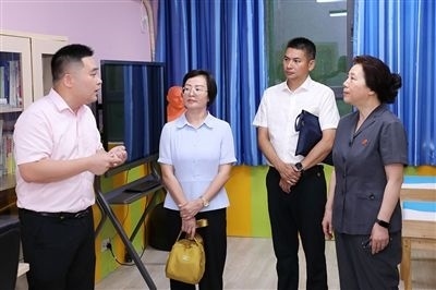 圖③：“小公民法律課堂”開講前，全國(guó)人大代表殷其龍（右二）、重慶市人大代表李自玲（左二）聽取楊家坪中學(xué)負(fù)責(zé)人關(guān)于未成年人思想教育工作情況的介紹。