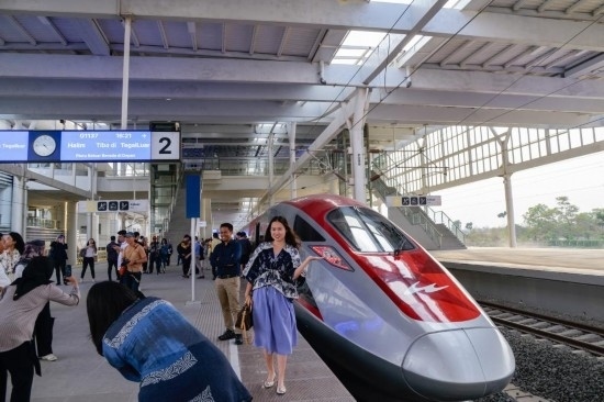 10月17日，在印度尼西亞萬隆德卡魯爾站，乘客在站臺上和雅萬高鐵高速動車組列車合影。新華社記者 徐欽 攝