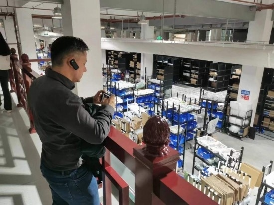 2023“一帶一路”媒體合作論壇聯(lián)合采訪團(tuán)團(tuán)員在仁和醫(yī)藥物流園拍攝記錄轉(zhuǎn)運(yùn)流程。（本報(bào)記者 黃超攝）