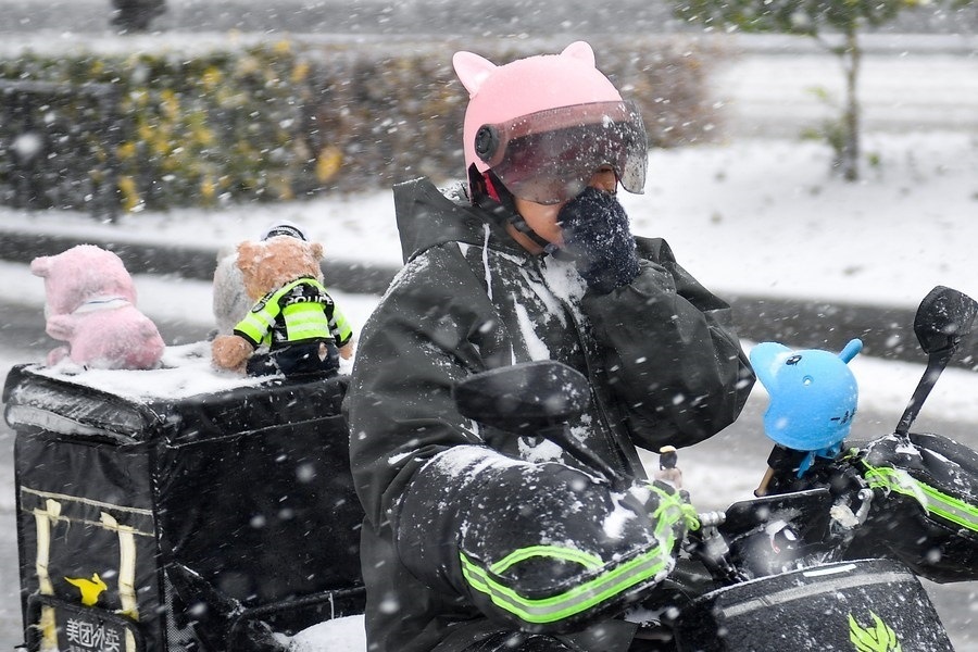 11月6日，在長春市街頭，一名外賣員在雪中騎行。新華社記者 許暢 攝
