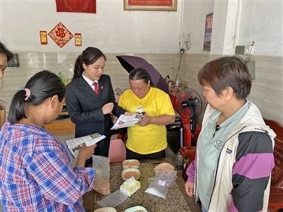  圖⑤：龍圩區(qū)法院法官到群眾家中開展法治宣傳。資料圖片