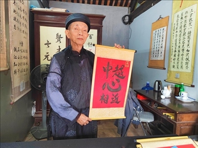 越南首都河內(nèi)文廟內(nèi)，阮明珠展示“中越心相近”書法作品。