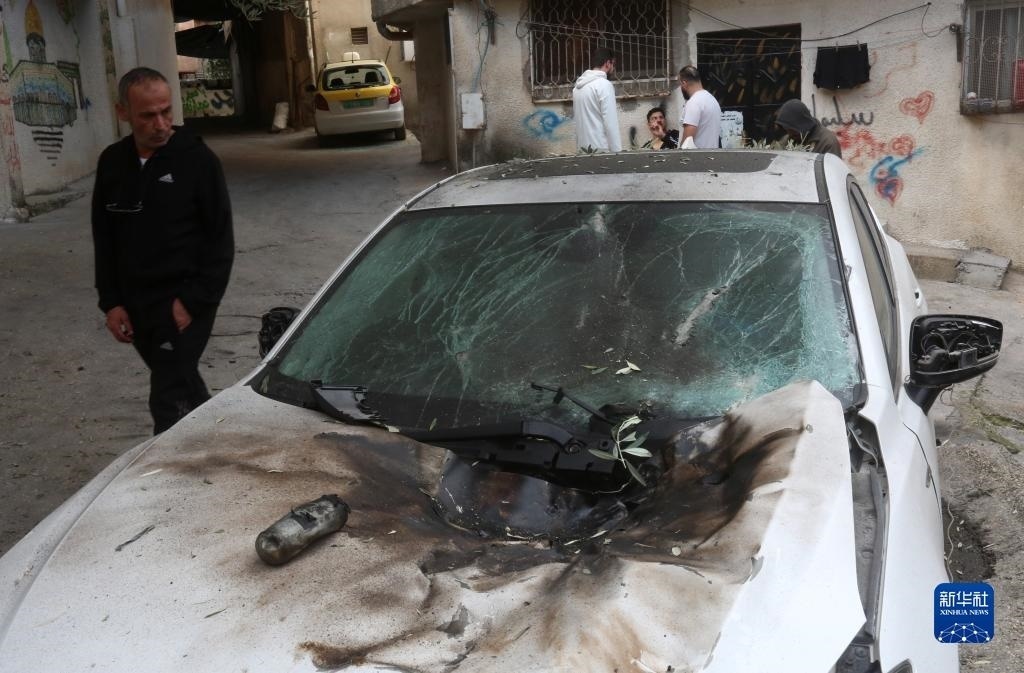 12月17日，在約旦河西岸城市圖勒凱爾姆附近的一處難民營，人們查看在沖突中損毀的車輛。新華社發(fā)（尼達爾·艾仕塔耶攝）