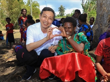 2023年12月18日，中國(guó)駐瓦努阿圖大使李名剛和前來(lái)觀看瓦努阿圖公路項(xiàng)目二期馬勒庫(kù)拉段移交儀式的當(dāng)?shù)鼐用窈嫌?。人民網(wǎng) 賀吉攝