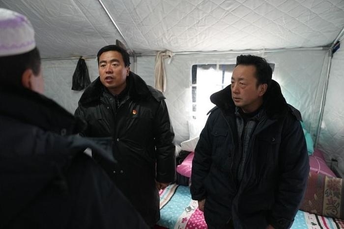 2023年12月22日，積石山縣大河家鎮(zhèn)大河村黨支部書記馬成忠（右二）在帳篷里和受災(zāi)群眾交流。新華社記者 陳斌 攝