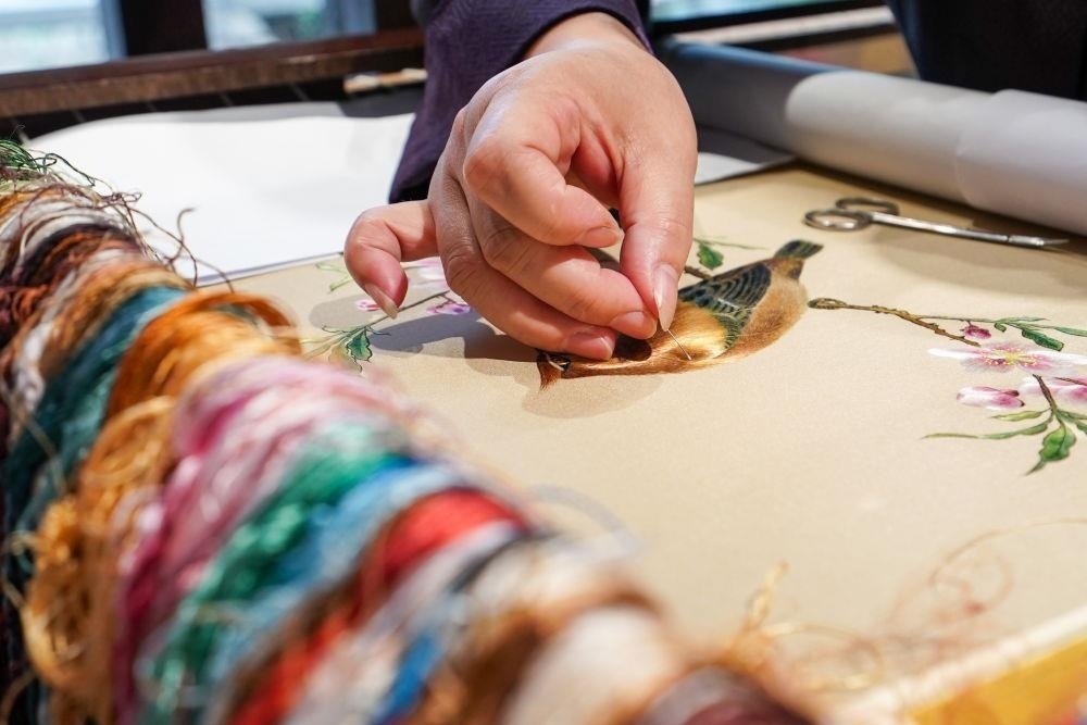 △2023年7月6日，盧建英在江蘇蘇州平江路的工作室內(nèi)刺繡。