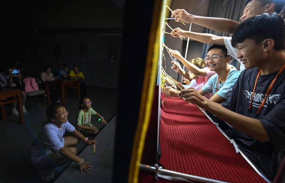 2023年8月8日，進行暑期研學(xué)的學(xué)生在位于陜西省西安市的中國秦腔藝術(shù)博物館體驗皮影戲演出。新華社記者 鄒競一 攝