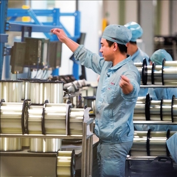 在位于武漢的長飛光纖光纜股份有限公司光纖生產(chǎn)車間內(nèi)，工作人員對光纖進行檢測（資料圖片）。肖藝九攝/本刊