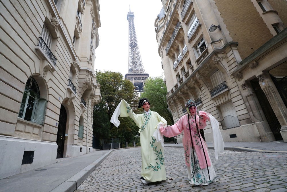 2023年9月13日，江蘇省演藝集團(tuán)昆劇院院長(zhǎng)施夏明（左）和江蘇省演藝集團(tuán)昆劇院國(guó)家一級(jí)演員孔愛(ài)萍在法國(guó)巴黎埃菲爾鐵塔附近參加昆曲快閃。新華社記者 高靜 攝