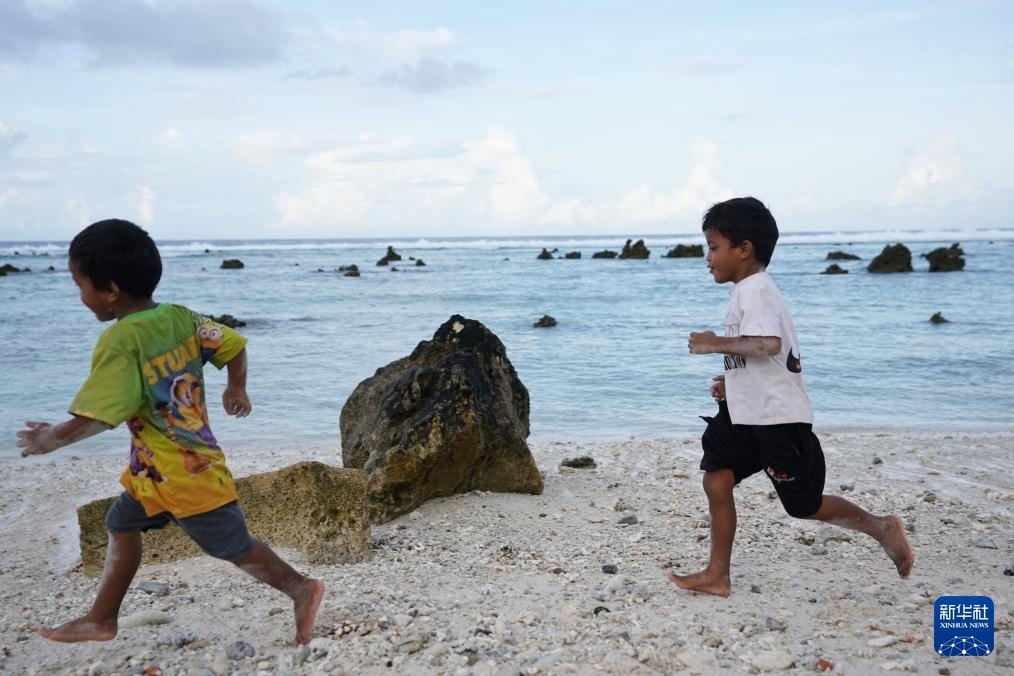 1月20日，兒童在瑙魯海邊嬉戲。新華社記者 王申 攝