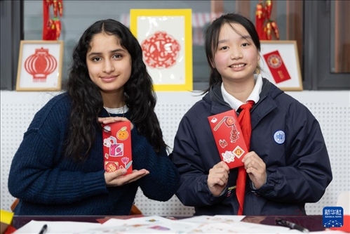 1月28日，美國馬斯卡廷中學(xué)學(xué)生（左）和復(fù)旦大學(xué)第二附屬學(xué)校學(xué)生展示互相送出的寫有寄語祝福的紅包。 新華社記者 王翔 攝