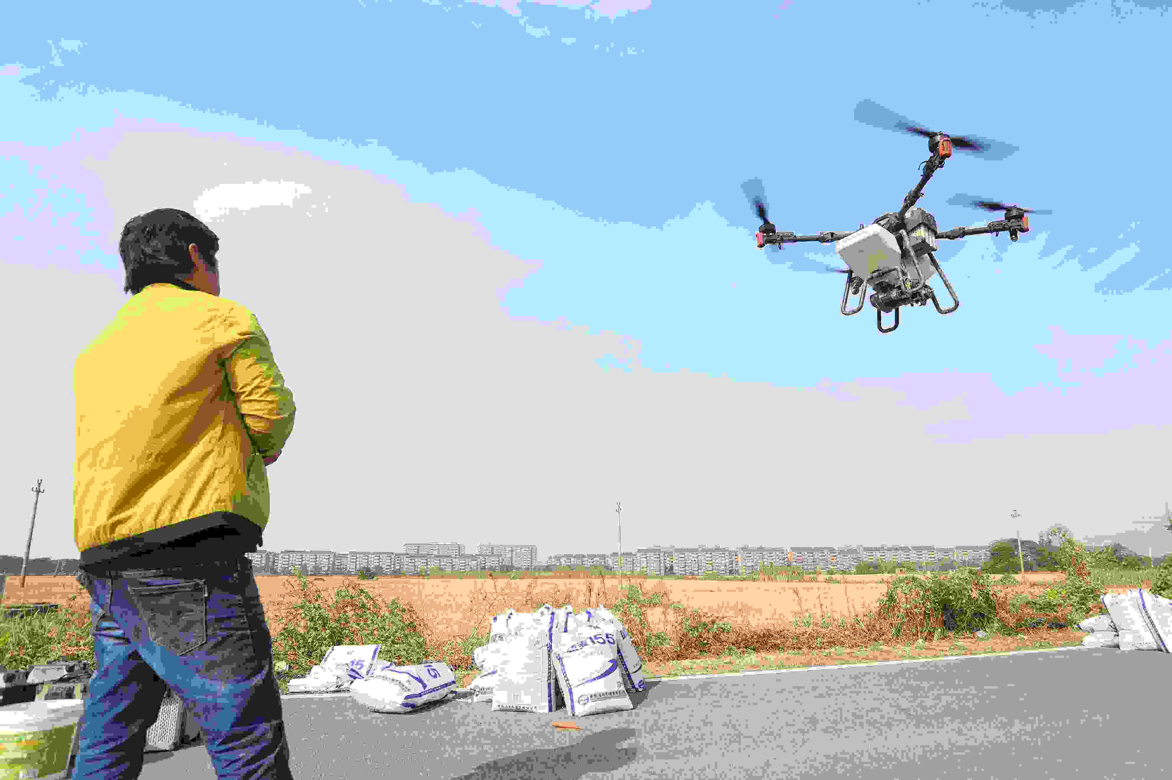 2023年11月15日，浙江嘉興，南湖區(qū)七星街道一處農(nóng)田里，農(nóng)民操縱無人機進行冬小麥飛播。