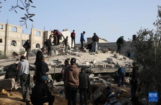  3月3日，在加沙地帶南部城市拉法，人們查看被以軍空襲破壞的建筑。新華社發(fā)（哈立德·奧馬爾攝）