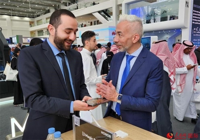 兩名觀眾在榮耀手機(jī)展臺前交流。人民網(wǎng)記者 管克江攝