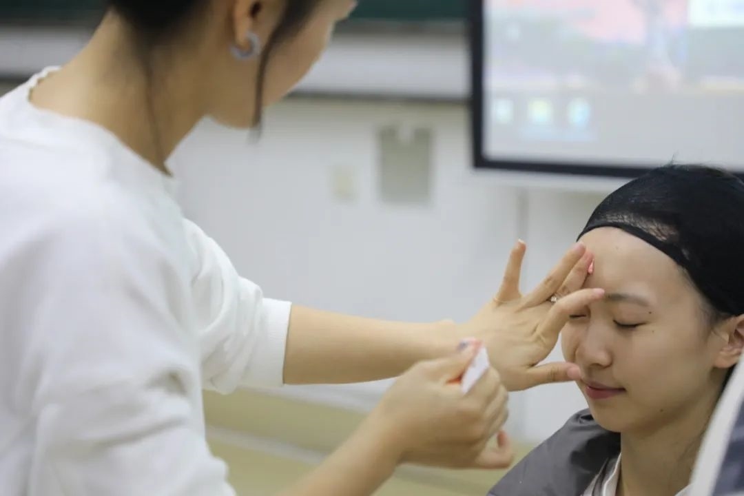 課堂上，一名學生在體驗上戲妝。學校供圖