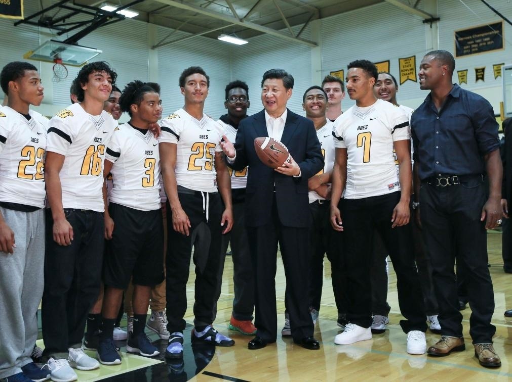 2015年9月23日，國家主席習(xí)近平參觀美國塔科馬市林肯中學(xué)。這是習(xí)近平在學(xué)校體育館，同上橄欖球訓(xùn)練課的學(xué)生們親切交談。新華社記者 蘭紅光 攝